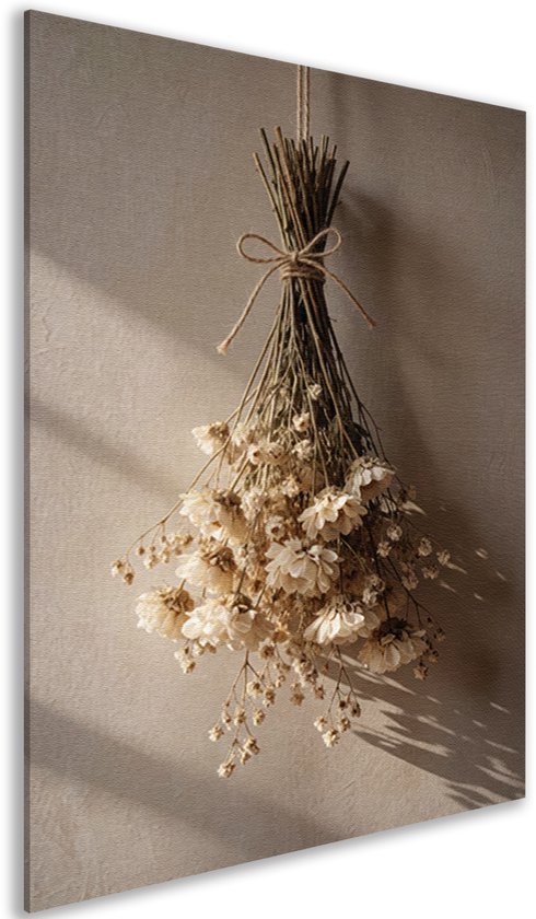 Zijaanzicht van een canvas schilderij met een bos beige droogbloemen vastgebonden met een touwtje op een licht canvas.