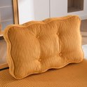 Gedetailleerde oranje corduroy rugkussen met knopen.