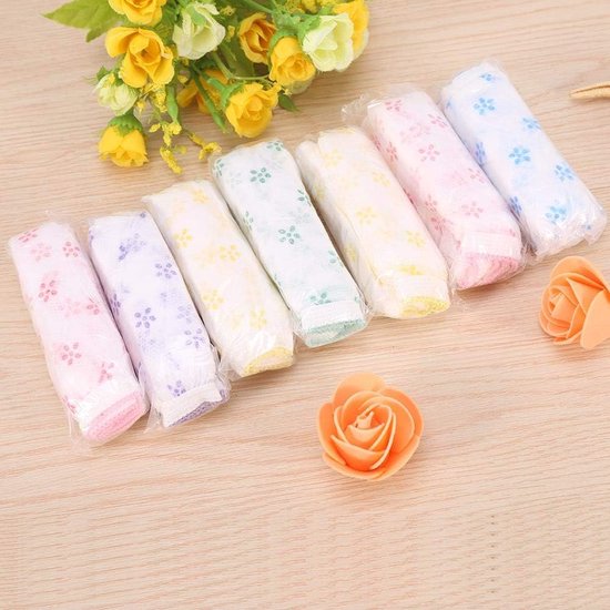 Zeven verpakte wegwerp-onderbroeken in pastelkleuren met bloemenpatroon, met gele en oranje decoraties op de achtergrond.