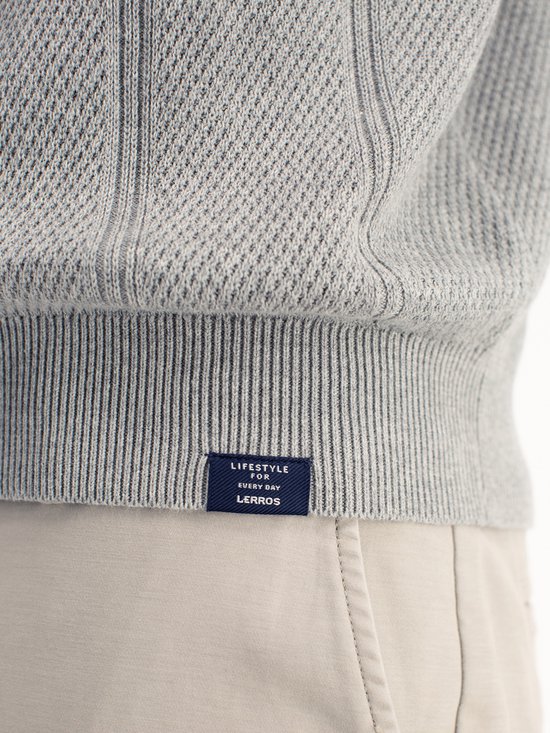 Detail van de zoom van de grijze polo met het label 'LIFESTYLE FOR EVERY DAY LERROS'.