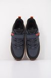 Donkerblauwe lage sneakers met oranje en zwarte details, klittenbandsluiting en veters.