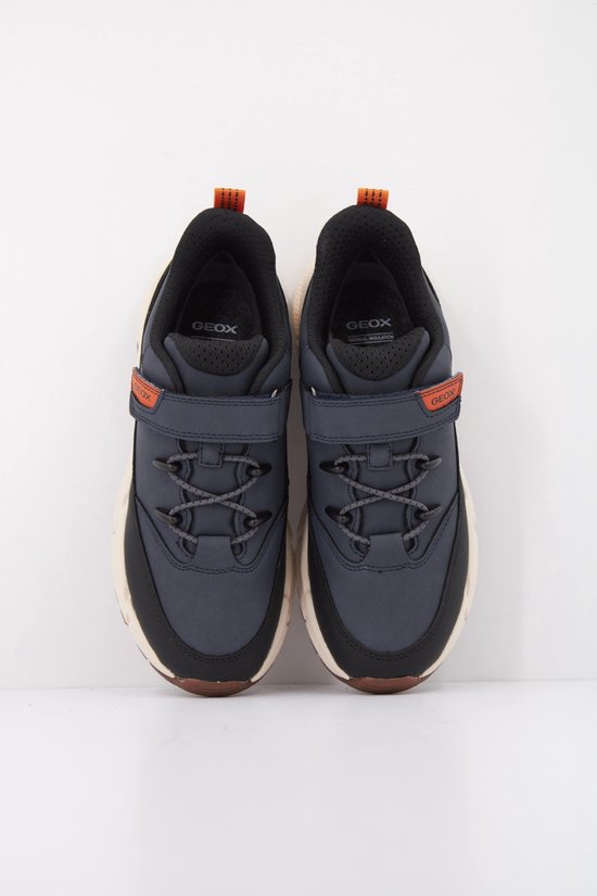 Donkerblauwe lage sneakers met oranje en zwarte details, klittenbandsluiting en veters.