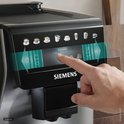 Vinger selecteert 'espresso' op het touchscreen van de zilverkleurige Siemens volautomaat.