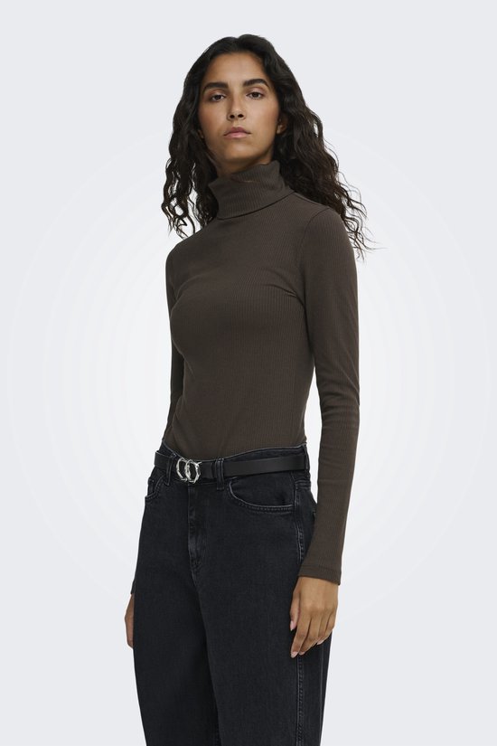 Close-up van model in een bruine, geribbelde coltrui en zwarte jeans met riem.