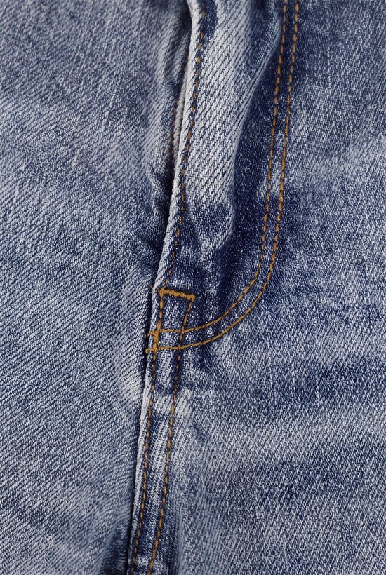 Close-up van de lichtblauwe denimstof met contrasterende oranje stiksels bij de gulp van de spijkerbroek.