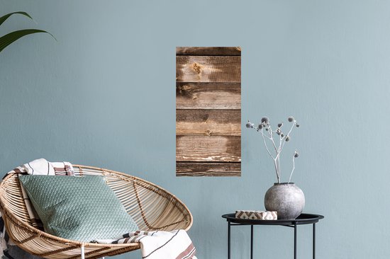 Planches verticales en bois brun avec des nœuds et des zones usées, suspendues dans un salon près d'une chaise.