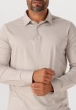 Man draagt een beige longsleeve poloshirt, detail van de kraag en mouwen.