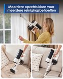 Vrouw gebruikt een Tineco stofzuiger met opzetstukken aan het plafond en op een bank.