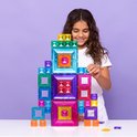 Meisje met krullend haar dat een hoge, gekleurde, magnetische Connetix toren bouwt.