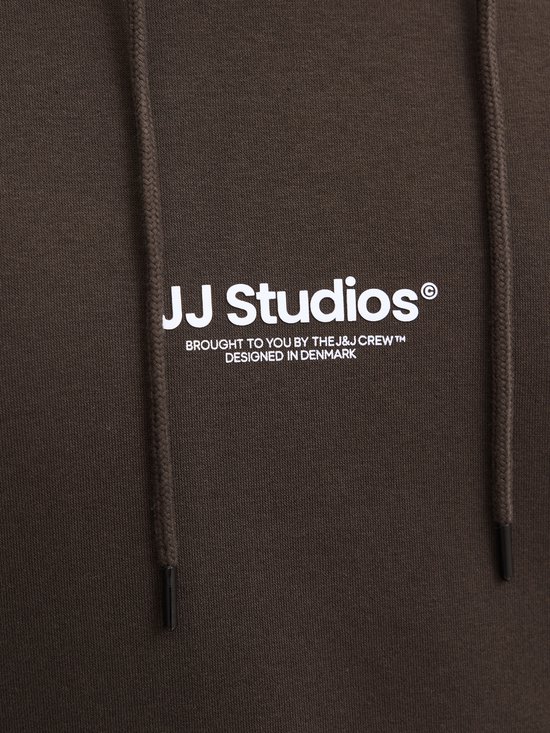 Bruine hoodie met het witte 'JJ Studios' logo en de tekst 'BROUGHT TO YOU BY THE J&J CREW™ DESIGNED IN DENMARK'.