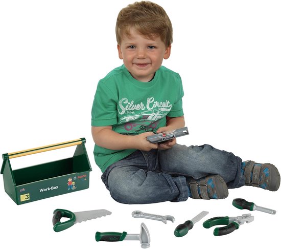 Garçon en t-shirt vert et jean avec une boîte à outils et des jouets d'outils.