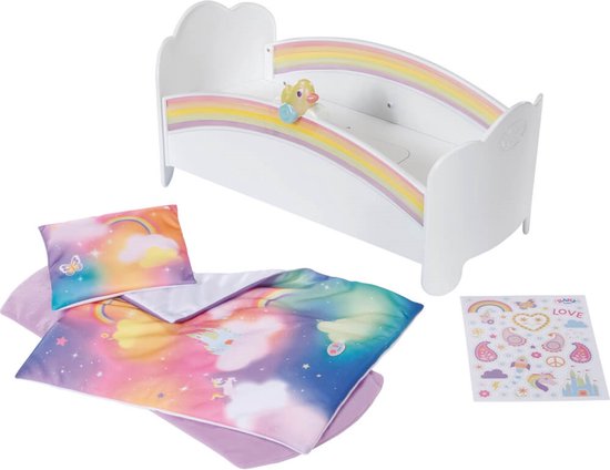 Wit ledikant met regenboogprint en accessoires, waaronder een dekbed met wolken en kastelen, een kussen, een matras en stickers.