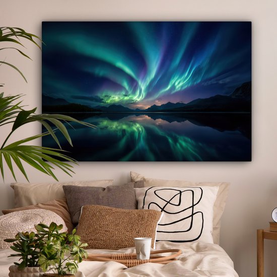Canvas schilderij van het Noorderlicht boven een bergmeer, boven een bed met kussens.