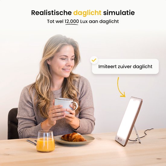 Vrouw geniet van ontbijt bij een daglichtlamp met bruin frame, die daglicht simuleert.