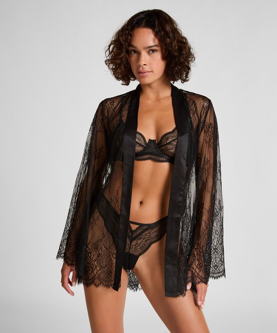 Model draagt zwarte kanten kimono met satijnen ceintuur.