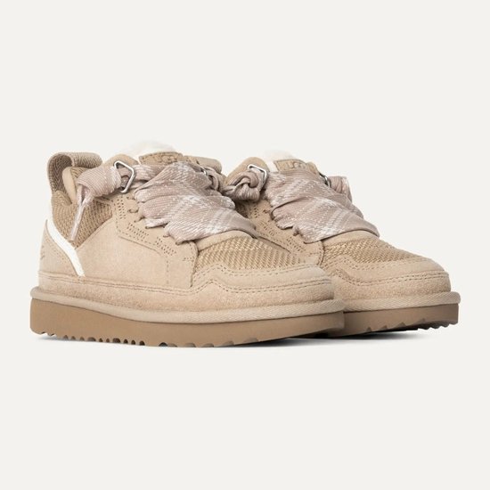 Beige UGG sneakers met bruine zool, schapenwollen voering en stoffen veters met ruitpatroon.
