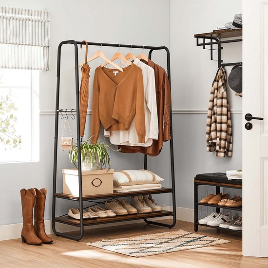 Zwart kledingrek met 2 houten planken, kleding, paraplu, schoenen en laarzen.