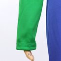 Groene mouw met nette zoom, vastgenaaid aan een blauw kledingstuk.