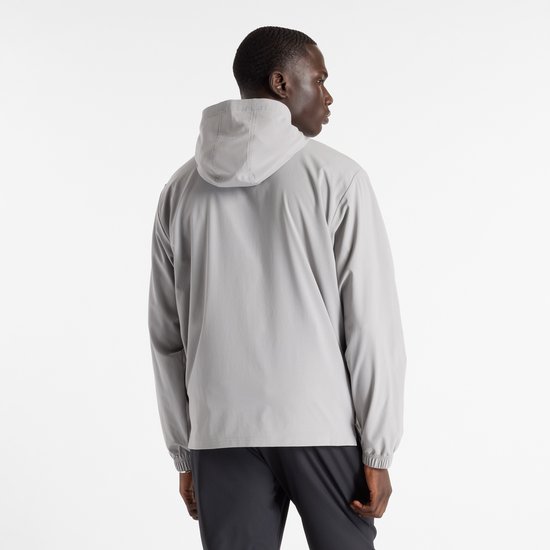 Man met grijze New Balance sportjas met capuchon, van achteren gezien.