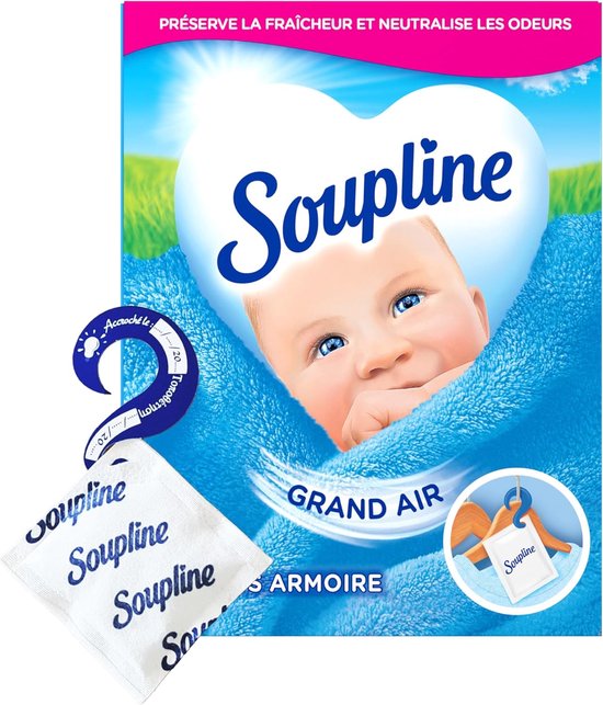 Gros plan d'un bébé endormi sur une serviette bleue, avec un paquet Soupline Grand Air et des sachets parfumés.