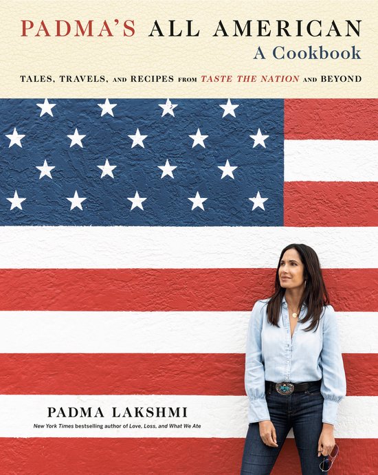 Padma Lakshmi staat voor een muur beschilderd als de Amerikaanse vlag, met een blauw en wit sterrenveld en rode en witte strepen.