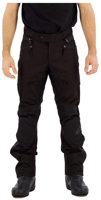 Pantalon de moto noir avec fermetures éclair et renforts aux genoux, porté par un homme.