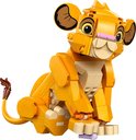 Gele LEGO Simba welp, zittend, met beige buik en groene plant.