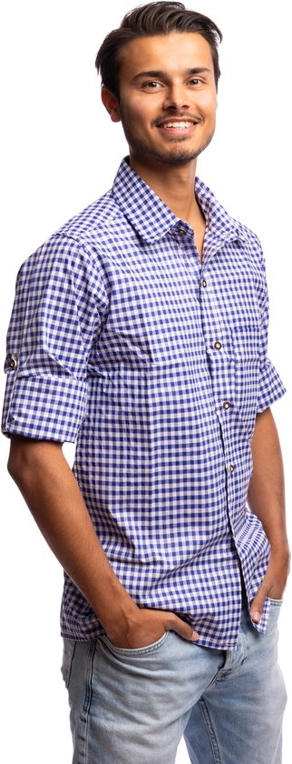 Man met blauw-wit geruite blouse en spijkerbroek, handen in de zakken.