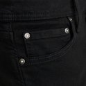 Detail van de zakken van een zwarte jeans met knopen.