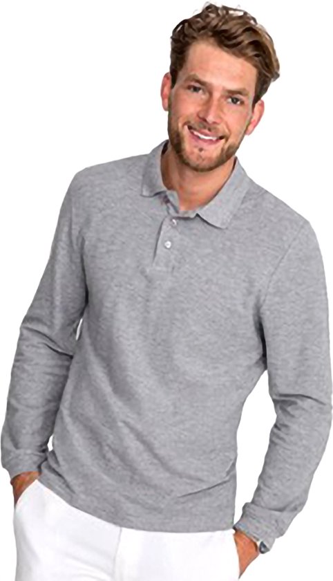 Man met lange grijze polo, witte broek, lachend naar de camera.