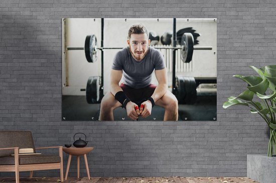Portrait d'un haltérophile amateur assis sur son banc de musculation Affiche de jardin 180x120 cm - Toile de jardin / Toile d'extérieur / Peintures d'extérieur (décoration de jardin) XXL / Groot format!
