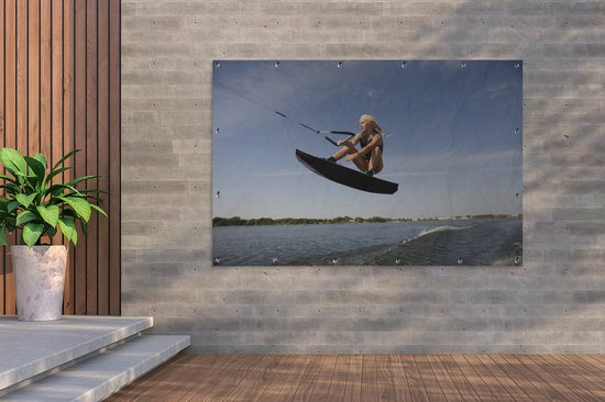 Une femme sportive s'agenouille sur un poster de jardin wakeboard 180x120 cm - Toile de jardin / Toile d'extérieur / Peintures d'extérieur (décoration de jardin) XXL / Groot format!