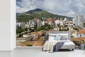 Behang - Fotobehang Stad voor een gebergte in Colombia - Breedte 420 cm x hoogte 280 cm