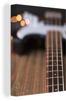 Une guitare basse repose sur le sol Toile 30x40 cm - petit - Tirage photo sur toile (Décoration murale salon / chambre)