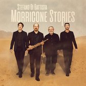 Stefano Di Battista et trois autres hommes marchent sur un sol sableux et désertique. Un homme porte un saxophone.
