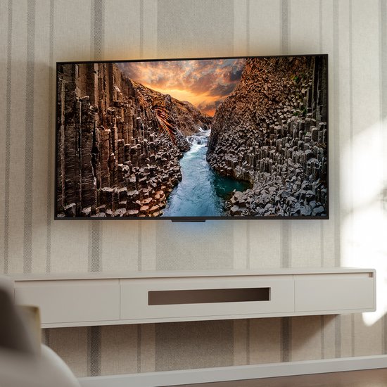 Een moderne woonkamer met een grote flatscreen-tv aan de muur.