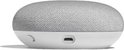 Zijaanzicht van een lichtgrijze Google Nest Mini met een micro-USB-poort aan de onderkant.