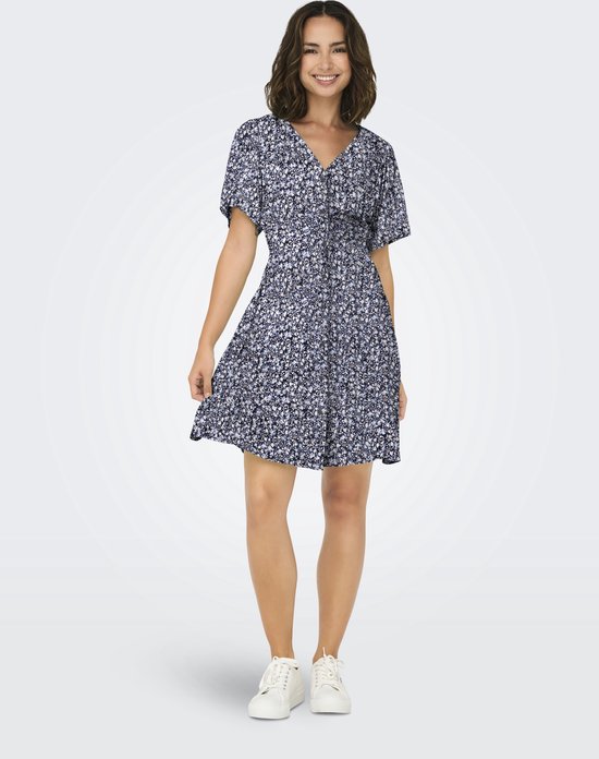 Femme portant une robe courte à imprimé floral bleu marine, manches courtes et col en V.