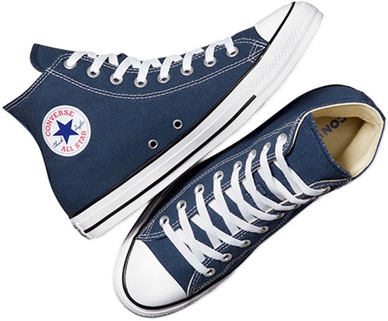 Twee donkerblauwe Converse All Star sneakers met witte veters, witte neuzen en witte zolen.
