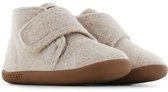 Een paar beige vilten slofjes met klittenbandsluiting en bruine zolen.