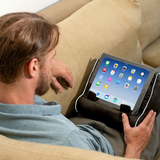 Man op bank met tablet op een zwart kussen