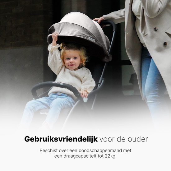 Een kind op een zwarte buggy, een vrouw loopt erachter.