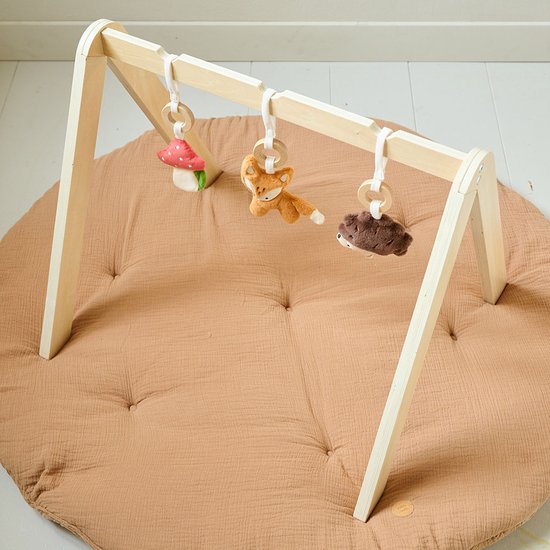 Houten babygym met paddestoel, vos en egel speeltjes boven een bruine speelmat.