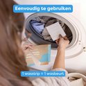 Een vrouw plaatst een witte wasstrip in een wasmachine met kleding. Doos met blauwe en bruine opdruk.