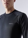 Close-up van zwart, geribbeld thermoshirt met ronde hals en grijs Craft-logo.