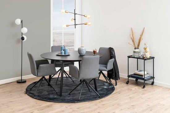 Een ronde zwarte tafel in een setting met grijze stoelen, een vloerkleed en een bijzettafel.