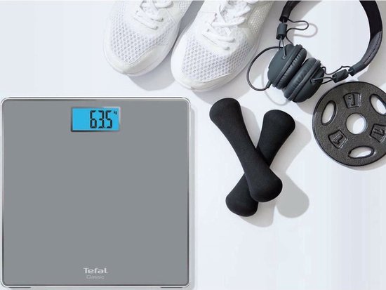 Balance Tefal grise avec des baskets blanches, un casque et des haltères.