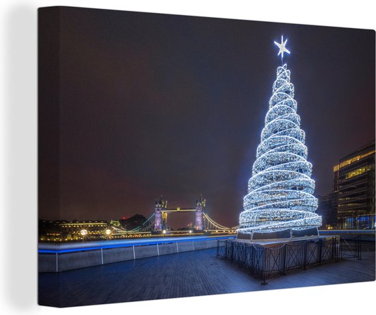 Canvas Schilderij Een verlichtte kerstboom bij de Tower Bridge in Engeland - 60x40 cm - Wanddecoratie