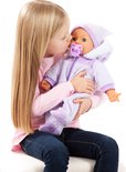 Een meisje met lang blond haar geeft een baby-pop met een paars, zacht pakje en muts een kus.