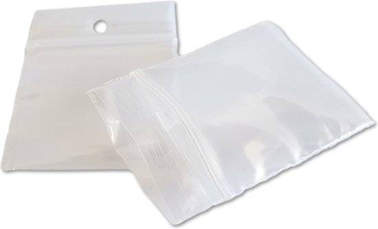 Twee kleine transparante gripzakjes, waarvan één met een hangertje. Naast een 50 cent muntstuk.